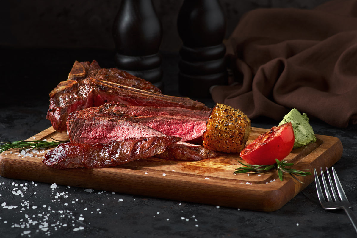 Grilled porterhouse steak sliced on a wood board — Stittsworth Meats, Bemidji MN