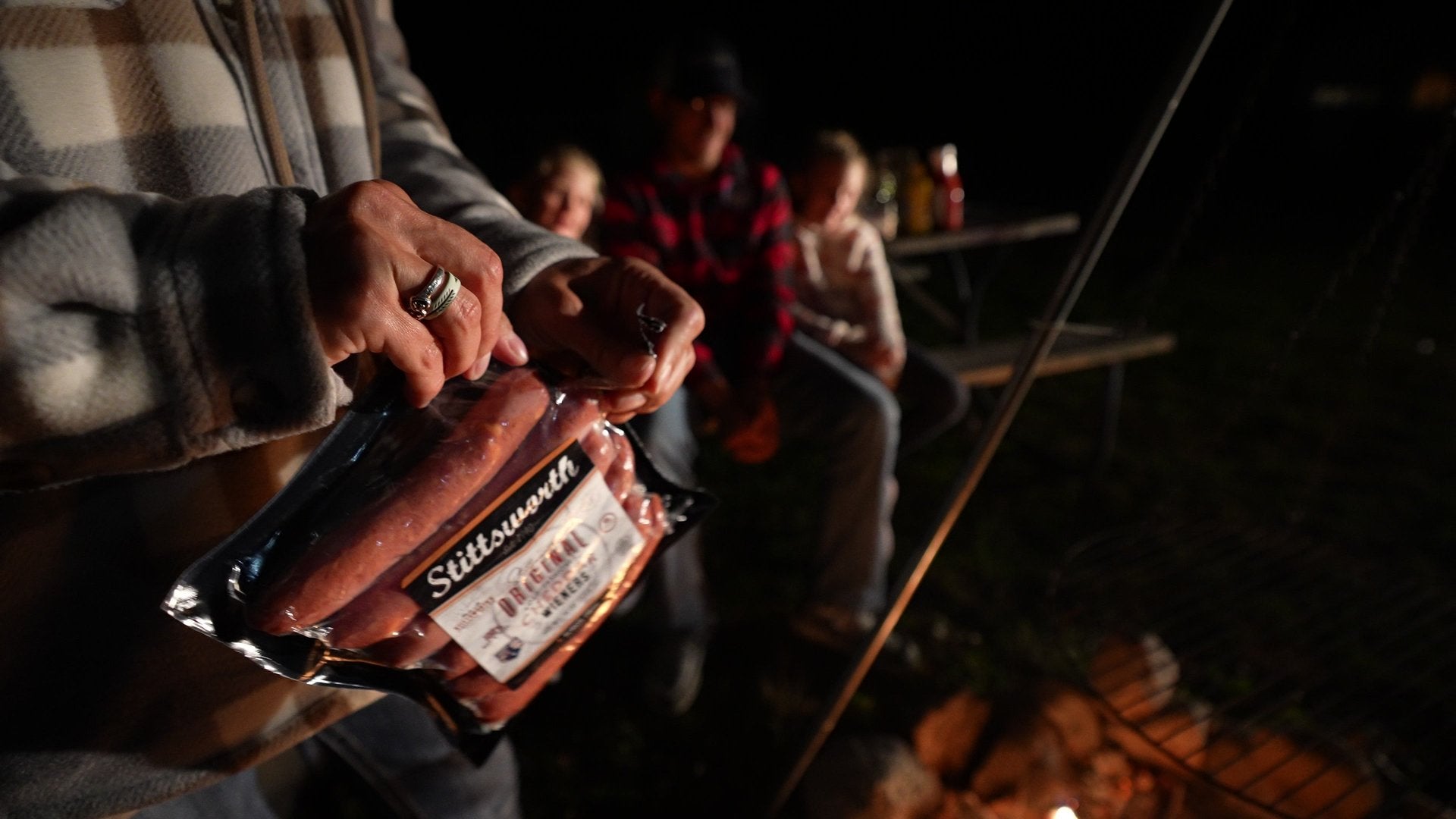 Family gathered around a campfire cooking Stittsworth Meats